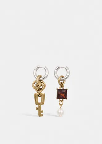 Mismatched gold and silver hoop earrings with charms